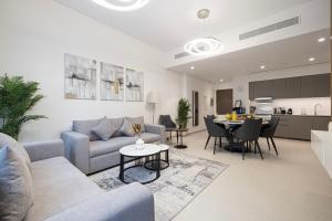 un soggiorno con un divano e un tavolo di EMAAR GRANDE - Elegant 1 Bedroom Apartment - Infinity Pool - 1min to Dubai Mall and Burj Khalifa a Dubai
