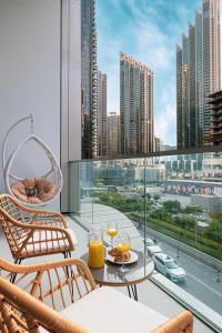 balcone con tavolo e 2 bicchieri di succo d'arancia. di EMAAR GRANDE - Elegant 1 Bedroom Apartment - Infinity Pool - 1min to Dubai Mall and Burj Khalifa a Dubai