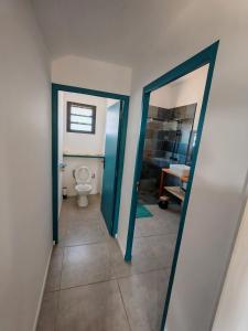 a bathroom with a toilet and a bathroom with a mirror at Case Lénora Les Cases de Langevin in Saint-Joseph