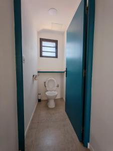 a bathroom with a toilet and a window at Case Lénora Les Cases de Langevin in Saint-Joseph