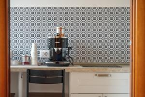 a kitchen counter with a black and white tile wall at kis inn affitacamere guesthouse in Rome