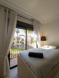 ein Schlafzimmer mit einem Bett und einem großen Fenster in der Unterkunft Ático Almyra - Roda Golf in San Javier