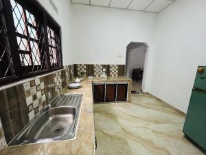 a kitchen with a stainless steel sink in a room at Rashini Villa in Beruwala