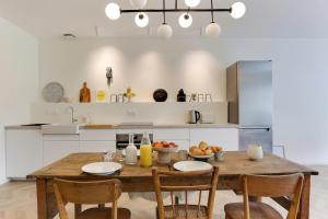une cuisine avec une table en bois avec des chaises et une cuisine avec un réfrigérateur dans l'établissement Maison Joseph - Chambre 2, à Saint-Jacques-de-la-Lande 5 autres photos