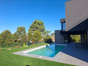 a swimming pool in the backyard of a house at Chalet de lujo con piscina cercano a la playa in Nigrán