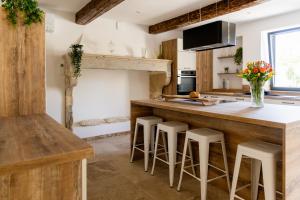 - une cuisine avec un comptoir en bois et des tabourets dans l'établissement Mas mes Aïeux, à Saint-Rémy-de-Provence