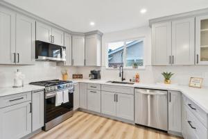 a kitchen with white cabinets and stainless steel appliances at Cozy Home with Hot Tub - Family-Friendly Yard home in Livermore