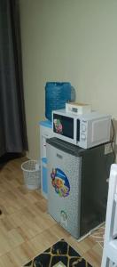 a microwave sitting on top of a refrigerator at Blissful Escape in Ongata Rongai 