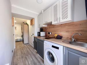 una cocina con lavadora y fregadero en RentHouse Apartments Sleep&Go #3, en Chişinău 14 fotos más