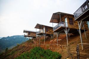 a group of houses on top of a hill at Mây home Trạm Tấu bungalow in Ya Ló