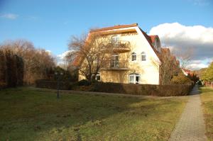 a large white building in a yard with a grass field at 4 You Apartmans in Egerszalók +29 photos