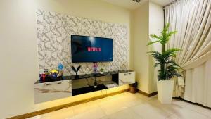 a living room with a flat screen tv on a wall at Luxus Gold Villa DHA Near Airport & Raya in Lahore