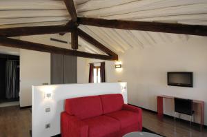 ein Wohnzimmer mit einem roten Sofa und einem Fernseher in der Unterkunft Hotel Cienbalcones in Daroca
