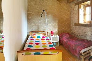 a bedroom with a bed and a chair in a room at Le Coin des Hortensias in La Puye +21 photos