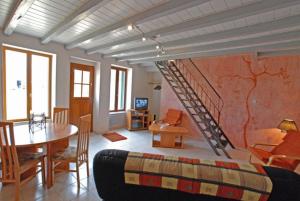 a room with a bed with a spiral staircase at Le Coin des Hortensias in La Puye