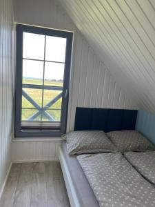 a bed in a room with a window at Słowiński Horyzont in Rowy
