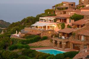 a house on a hill with a swimming pool at Blue Dawn in Capo Coda Cavallo