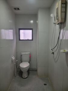 a small bathroom with a toilet and a window at Noorjahan Guesthouse Pattaya in Pattaya Central