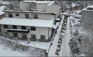 Apartament Kacperek samo centrum, Willowa 4A - 2 sypialnie, salon - dla rodziny 4-5 os في شتوروك: مبنى مغطى بالثلوج مع وجود لافتة عليه