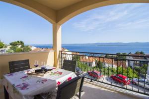 a table on a balcony with a view of the water at Villa Marina Bol in Bol
