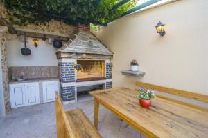 a patio with a wooden table and a fireplace at Villa Marina Bol in Bol
