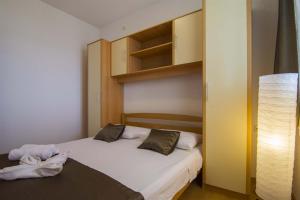 a small bedroom with two beds and a lamp at Villa Marina Bol in Bol