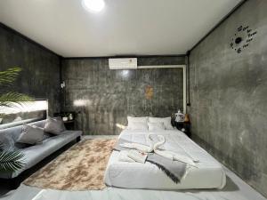a bedroom with a large bed and a couch at Missme Homestay-มิสมีโฮมสเตย์ in Ban Mae Na