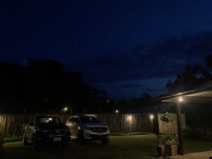 a couple of cars parked in a yard at night at Missme Homestay-มิสมีโฮมสเตย์ in Ban Mae Na +4 photos