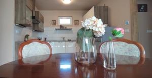 two vases with flowers sitting on a table in a kitchen at White Column House in Diósd +22 photos