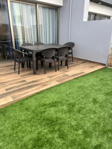 a dining room with a table and chairs and green grass at Villa West Park, Kyrenia in Kyrenia