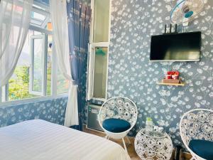 una camera con un letto, due sedie e una TV di Villa - Hotel Nam Khang 2 Dalat a Da Lat