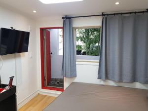 a bedroom with a bed and a tv and a window at Studio 6 in Seoul