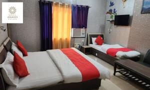 a bedroom with two beds with red and white at Hotel Anand Palace in Jawāla Mukhi