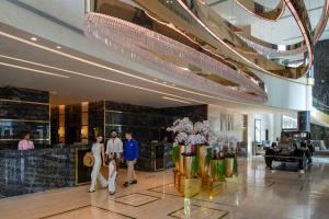 grupa ludzi przechodzących przez hol w obiekcie Dusit Doha Hotel w mieście Doha +37 zdjęć