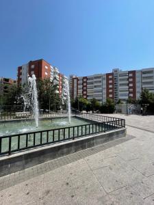 a fountain in a park with buildings in the background at Cozy Apartment in Gjilan in Gnjilane