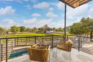 ELIVAAS Cows & Cuddles 4 BHK with Pvt Pool and Garden的阳台或露台
