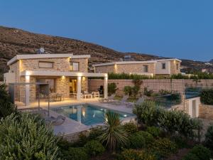 a villa with a swimming pool in front of a house at Alki Villas Collection -Luxury Sea View Villas -Breakfast Included-Falasarna in Falasarna