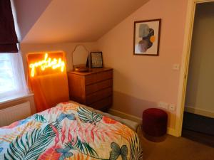 a bedroom with a bed and a dresser with a light at Cosy flat in central Wellington in Telford