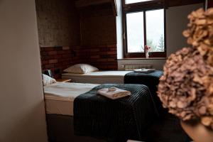 a room with two beds and a window at Dworek Galosa in Stronie Śląskie