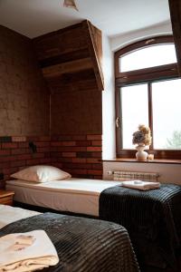a bedroom with two beds and a window at Dworek Galosa in Stronie Śląskie