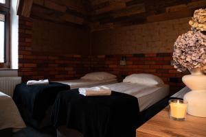 a room with two beds and a table with a vase at Dworek Galosa in Stronie Śląskie