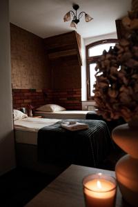 a bedroom with a bed with a candle and a window at Dworek Galosa in Stronie Śląskie