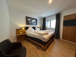 a bedroom with a bed and a chair and a window at Ferienwohnung Amalie in Füssen