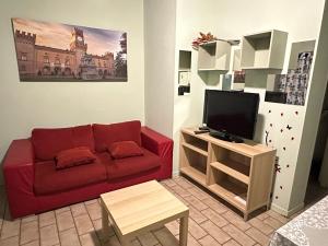 a living room with a red couch and a tv at Naviglio 34 in Parma
