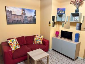 a living room with a red couch and a tv at Naviglio 34 in Parma