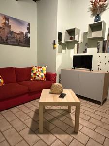 a living room with a red couch and a coffee table at Naviglio 34 in Parma