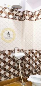 a bathroom with a sink and a tiled wall at Urmila Homestay And Boutique in Jaisalmer +35 photos