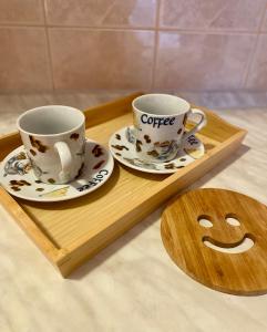 two coffee cups and saucers on a wooden tray at Apartment Victor in Banja Koviljača +5 photos