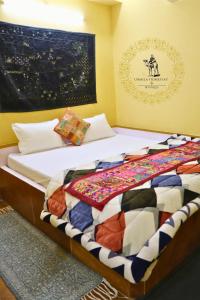a bedroom with a bed with a quilt on it at Urmila Homestay And Boutique in Jaisalmer
