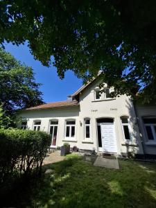 a white house with a door in a yard at Ferienwohnung Meeresglück in Kruså